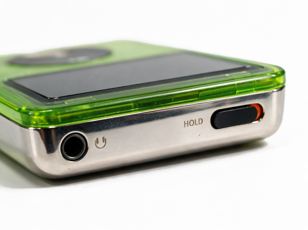 Frost &mdash; top edge, headphone jack and hold switch, translucent neon green iPod Classic.